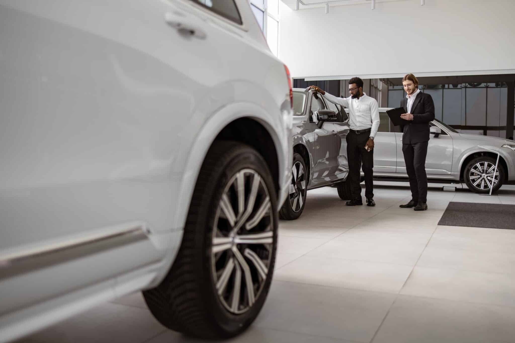 Grayscale vehicles on a showroom floor.