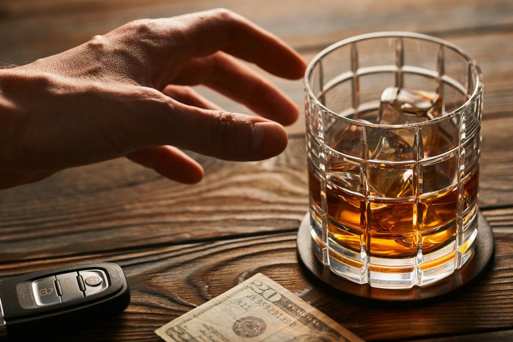 mans hand reaching to glass with alcohol drink PTCU224