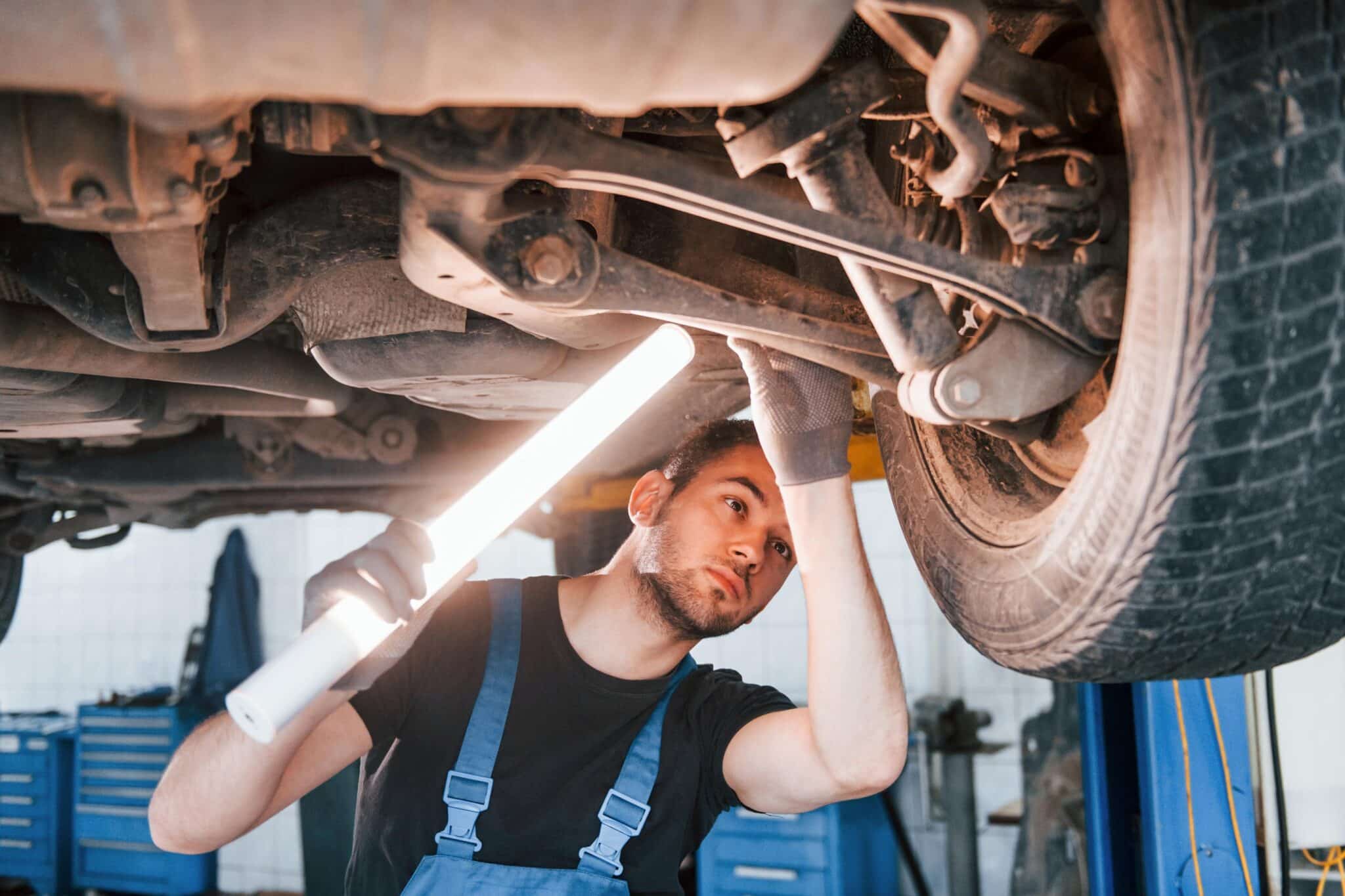 Mechanic with Lamp Doing a Multi Point Inspection scaled